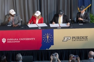 A photo of Indiana University and Purdue officials signing an agreement to split IUPUI into two institutions.